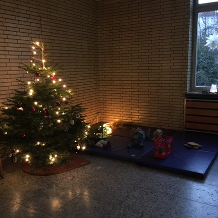 Geschmückter Tannenbaum im Foyer. Daneben liegen einige Sportmatten auf dem Boden.