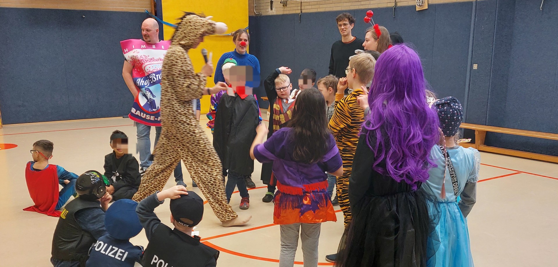 Kinder feiern in einer Turnhalle Karneval.